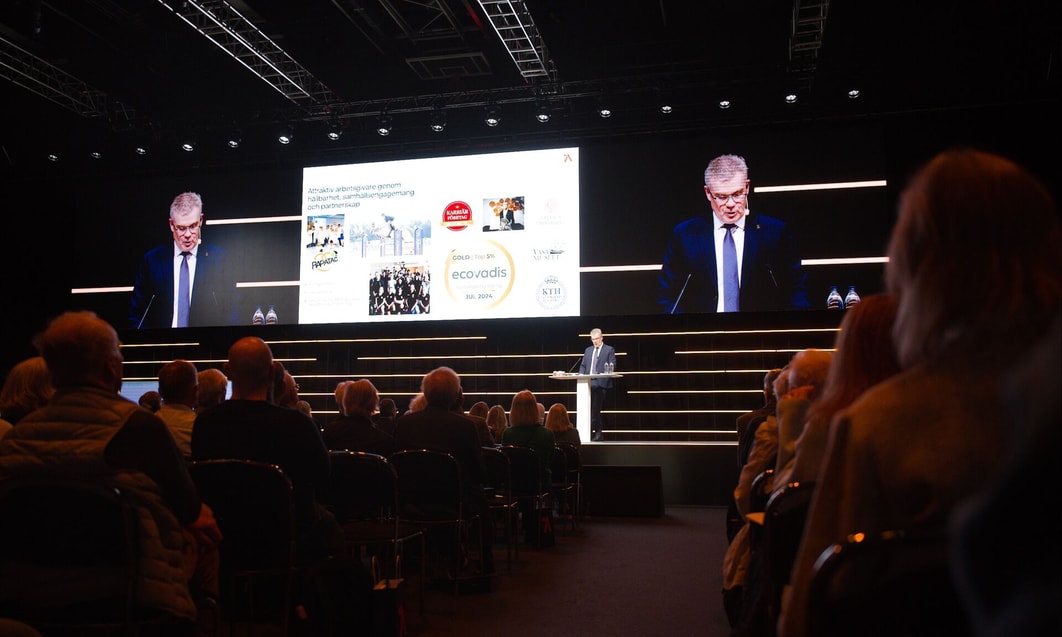 a person standing in front of a stage with a large screen