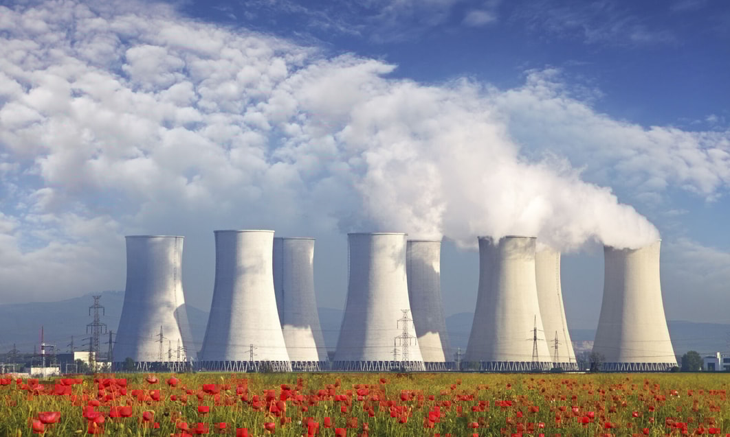 a group of nuclear power plant with smoke coming out of the chimney