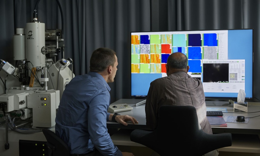 a group of men looking at a computer screen
