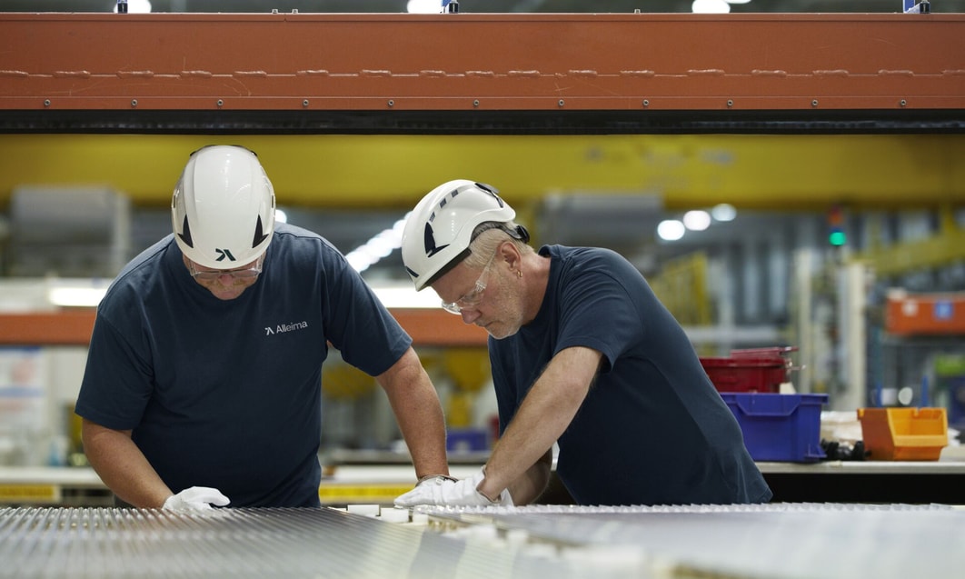 men wearing white helmets and gloves working on a machine