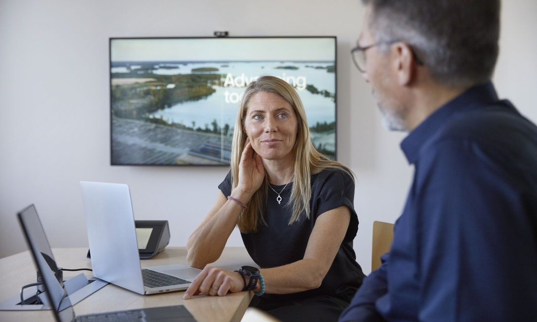 a person and person sitting at a table with a laptop