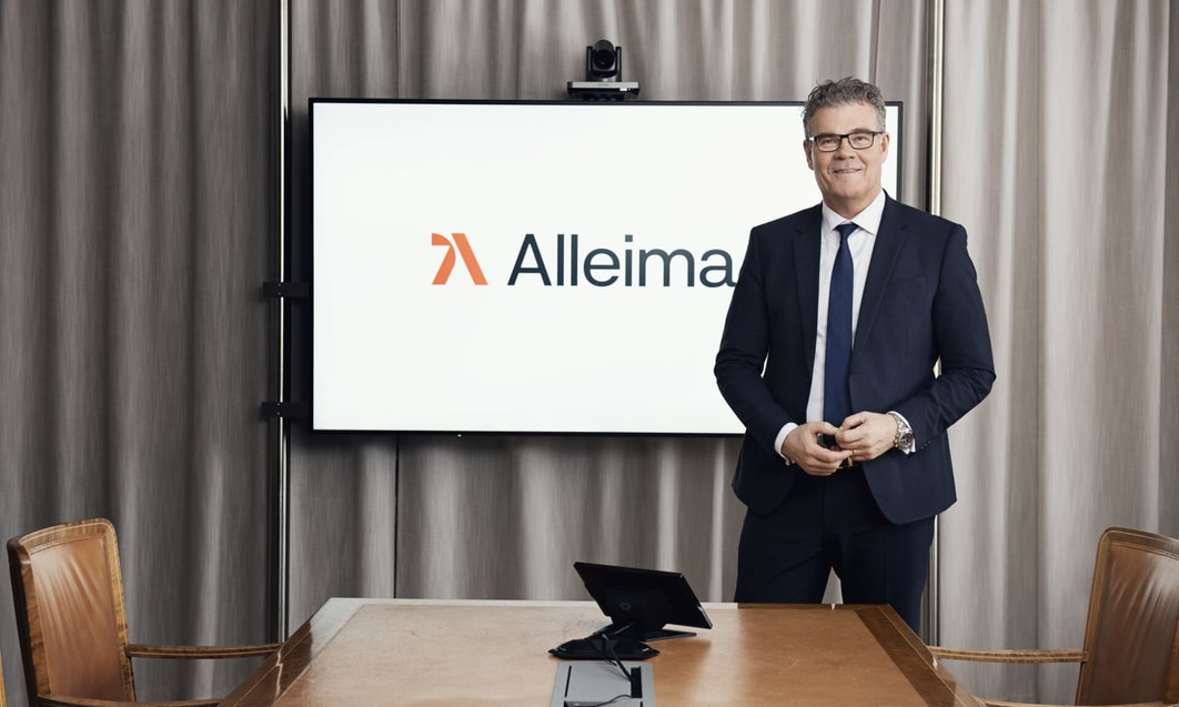 a person in a suit standing in front of a screen