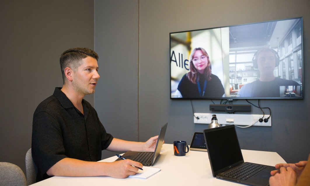 a person sitting at a table with laptops and a laptop on it