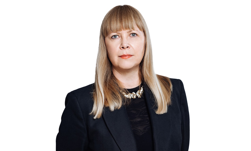 a person with blonde hair wearing a black suit