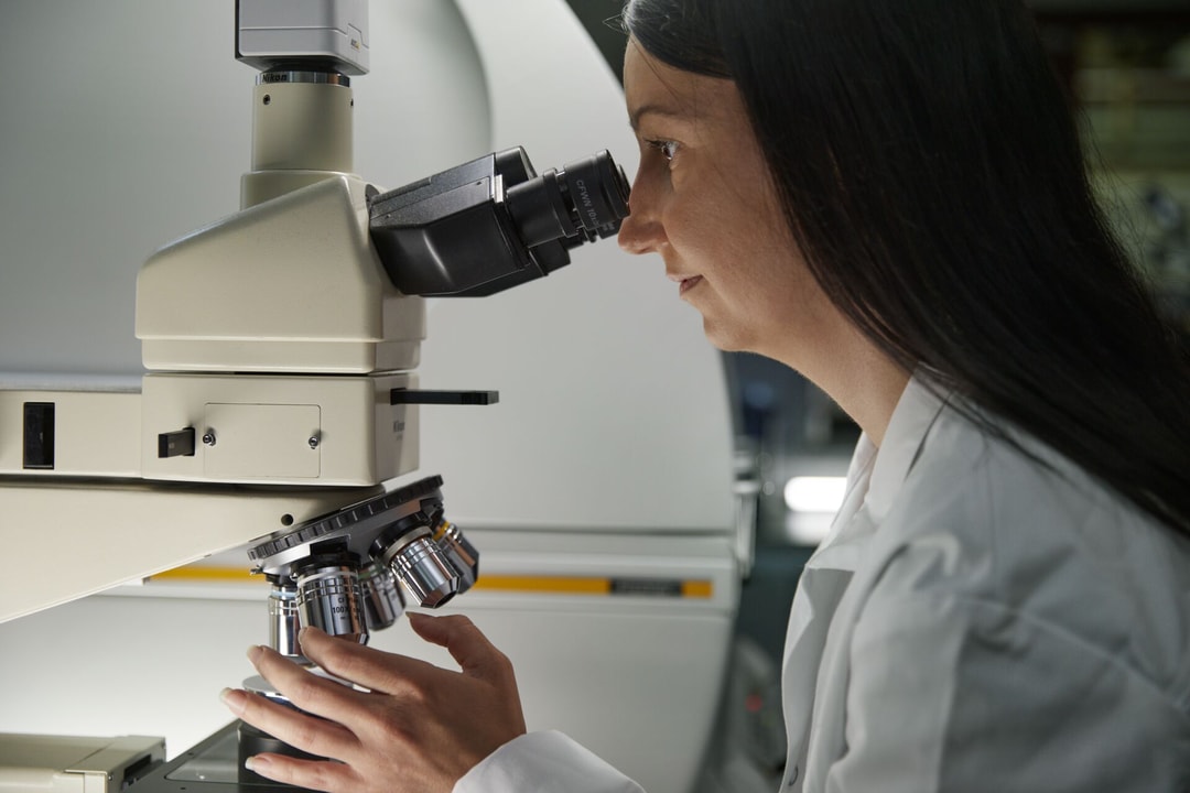 a person looking through a microscope