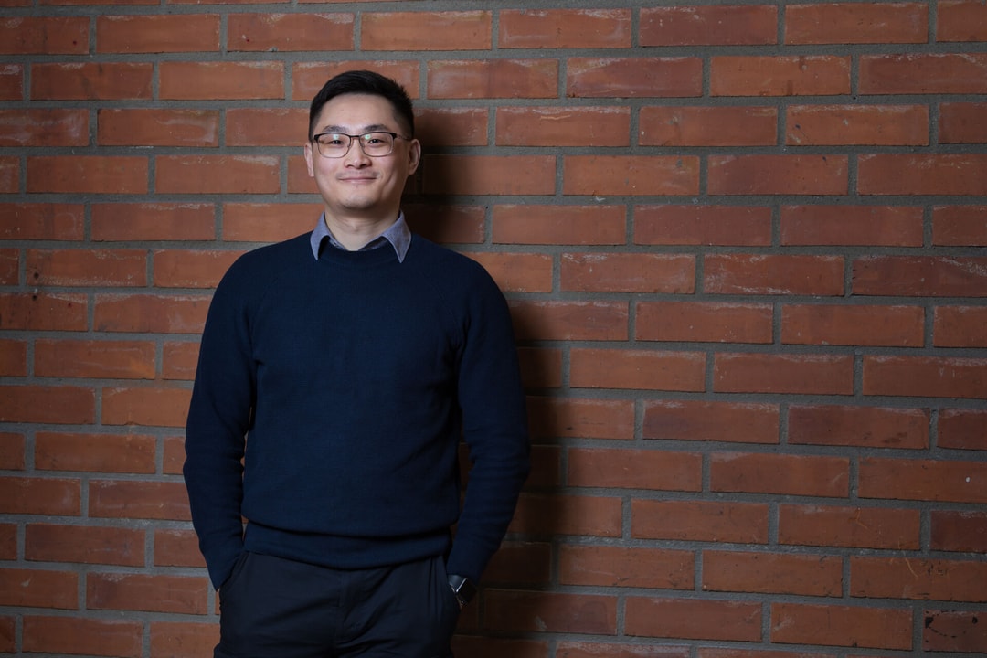 a person standing in front of a brick wall