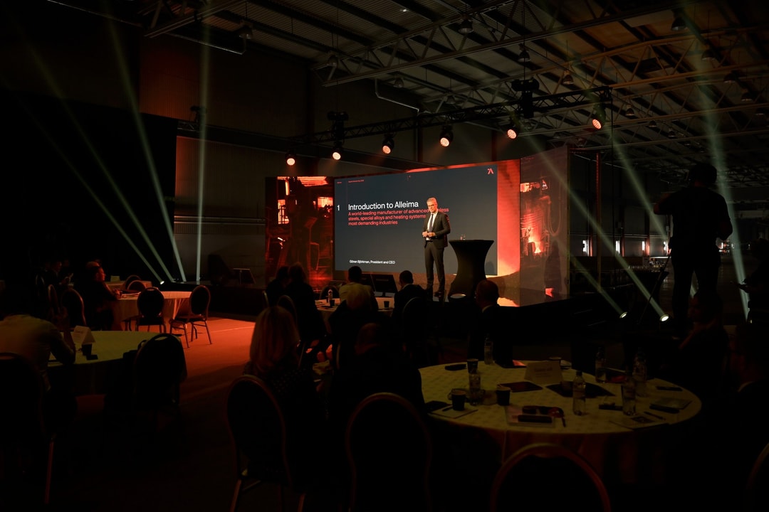 a person standing on a podium in front of a large screen