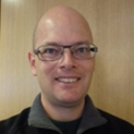a person wearing glasses and smiling