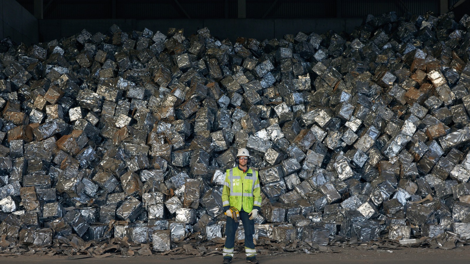 a person standing in front of a large pile of metal