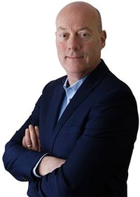 a person in a suit with his arms crossed