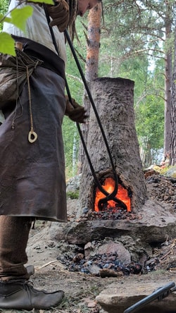 a person in a robe by a fire