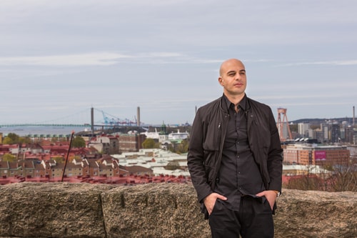 en person som står på en avsats med en stad i bakgrunden