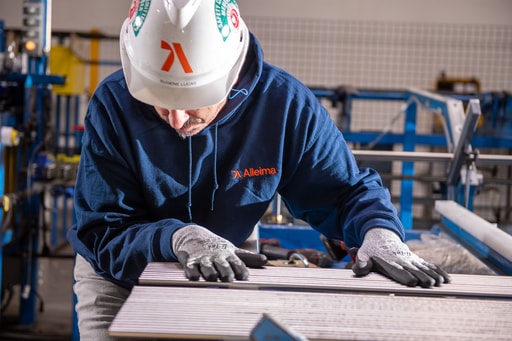 a person wearing a hard hat and gloves working on a metal surface