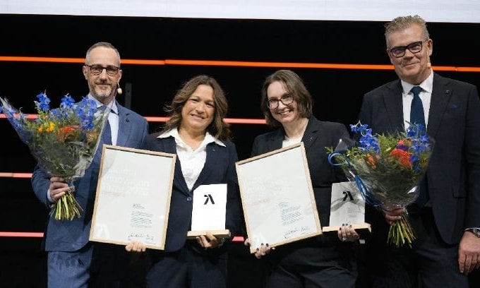 a group of people holding certificates and flowers
