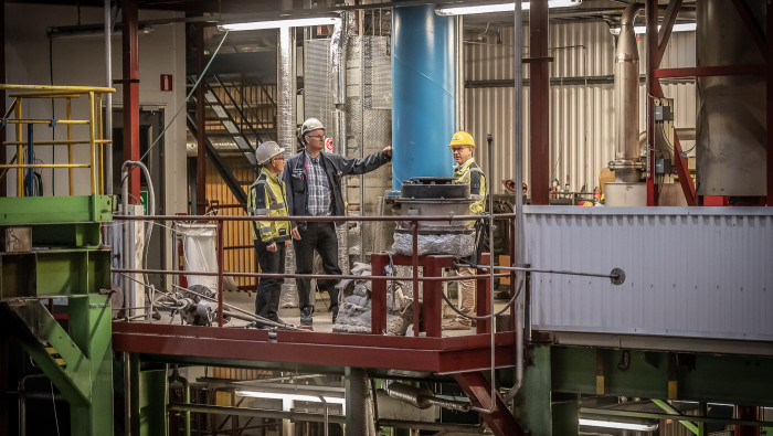 a group of men in hard hats standing on a platform