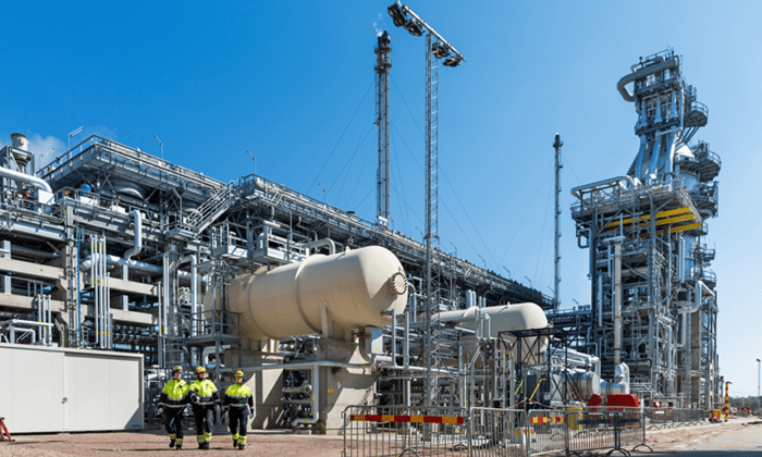 a group of people standing in front of a factory