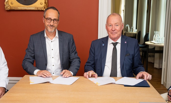 two men sitting at a table with papers