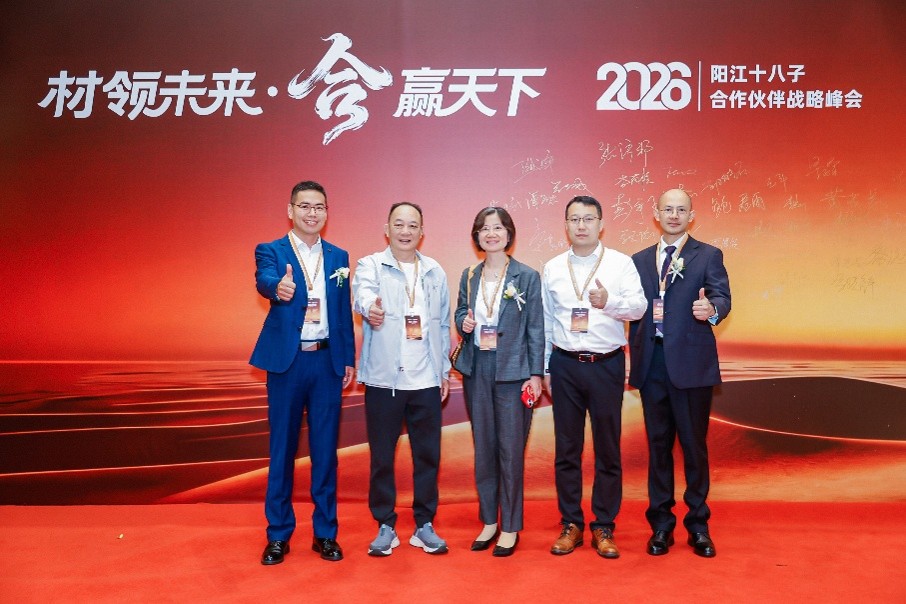 a group of people standing in front of a red wall