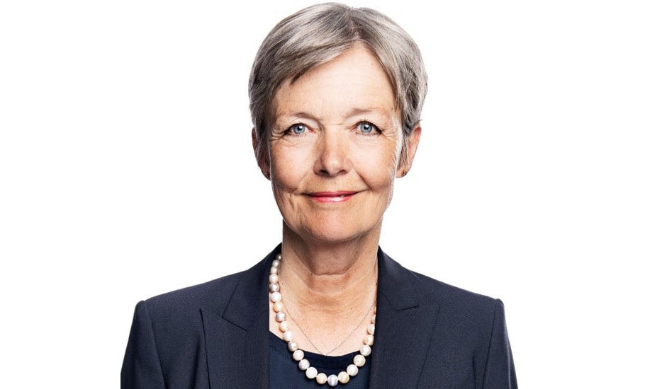 a person wearing a black suit and a pearl necklace